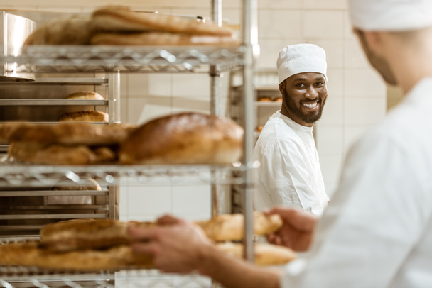 panaderos jóvenes que trabajan juntos en la fabricación de panadería
 - Foto, Imagen