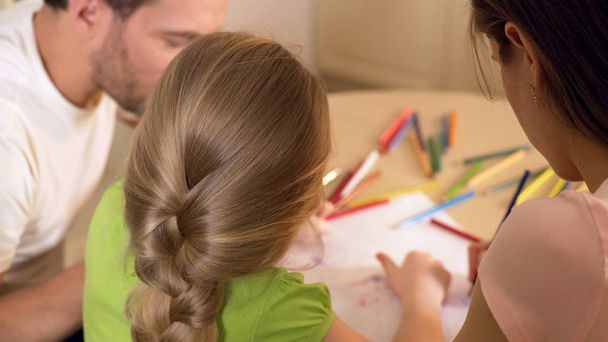 Family drawing colorful pictures with pencils, parents enjoying time with kid - Photo, Image