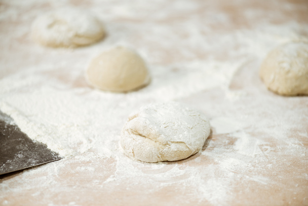 close-up shot of dough ball on table spilled with flour - Fotó, kép