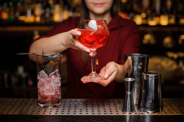 Bartender girl serving a light red cocktail - 写真・画像