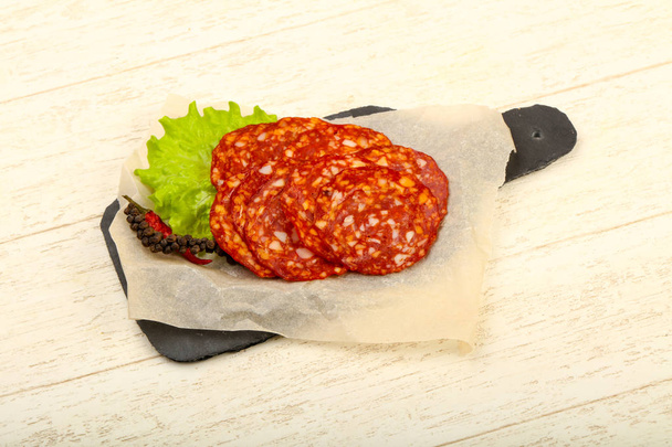Affettato gustosa salsiccia Chorizo sullo sfondo di legno
 - Foto, immagini