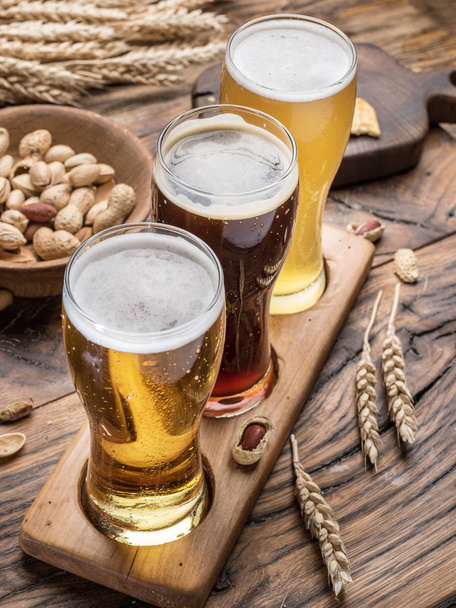 Glasses of beer and snacks on the wooden table. - Fotoğraf, Görsel