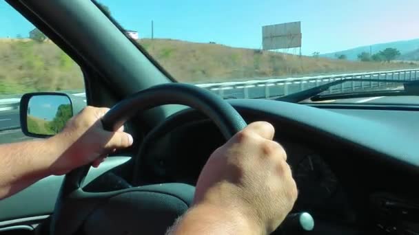 El hombre está conduciendo sosteniendo la rueda del coche
 - Metraje, vídeo