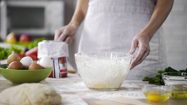 Bakery worker holding flour sieve for adding into glass bowl, pizza recipe tips - Foto, Imagem