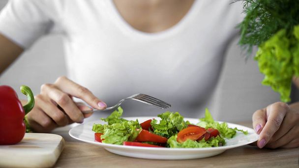 Femme assise à la table avec assiette de salade, alimentation saine, soutien énergétique
 - Photo, image