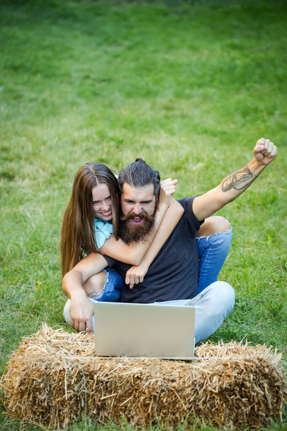 Couple in love use laptop on nature, internet surfing - Foto, afbeelding