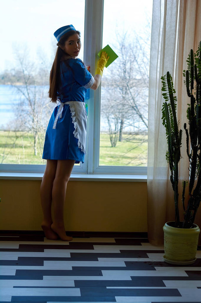 Csinos szobalány tisztító ablak. - Fotó, kép