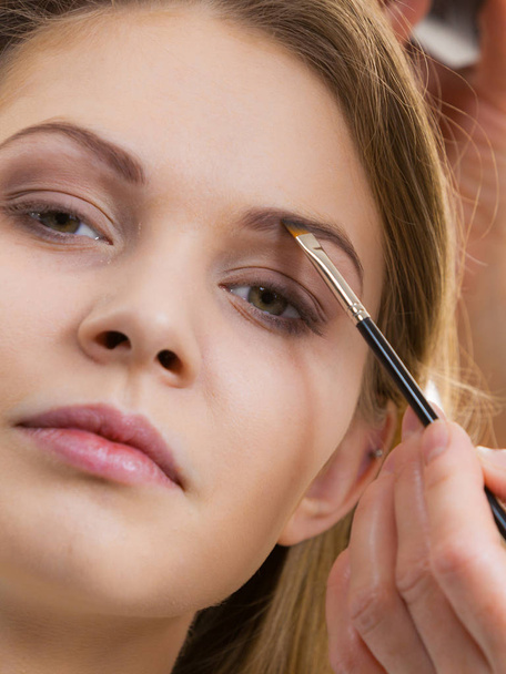 Frau lässt sich Augenbrauen schminken - Foto, Bild