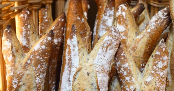 φρέσκο ζυμωτό ψωμί στο αρτοποιείο, οργανικά ψωμιά ολικής αλέσεως, όμορφη νόστιμο γαλλικό στυλ μπαγκέτα χειροποίητο, χρυσή καφετιά baker εμφάνιση σε κατάστημα, κακότροπος τρυφερά φρέσκα σπιτικά - Πλάνα, βίντεο