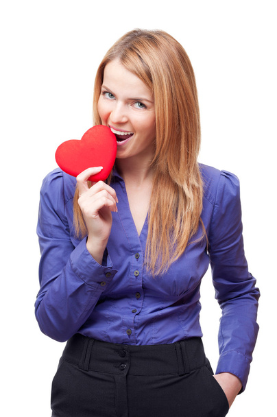 Business woman or student standing and gnawing red heart - Fotografie, Obrázek