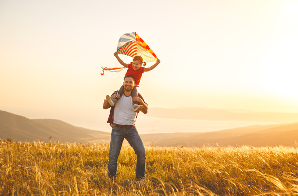 gelukkig gezin vader en kind dochter uitvoeren met kite op meado - Foto, afbeelding