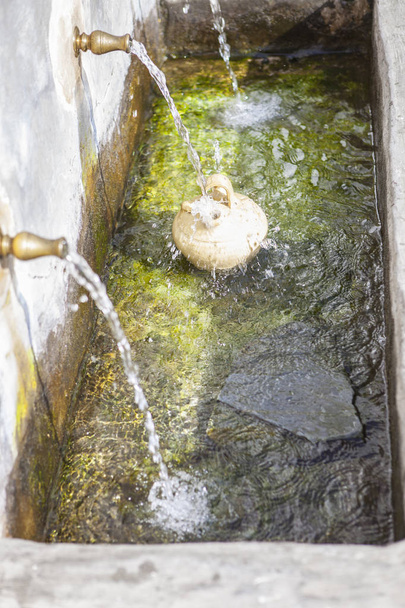 Ένα botijo είναι γεμάτη με φρέσκο νερό σε δημόσια κρήνη στο Alpuja - Φωτογραφία, εικόνα
