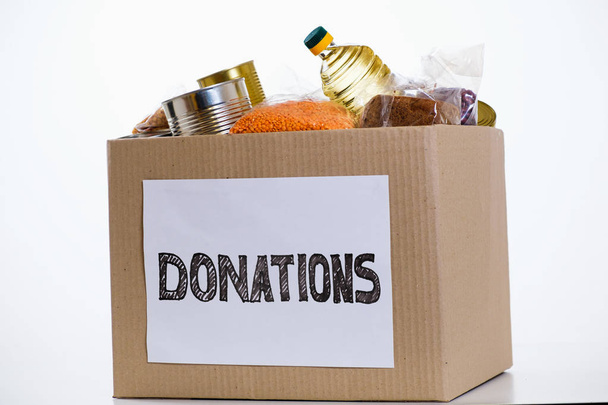 Food in donation cardboard box, isolated on white background - Φωτογραφία, εικόνα