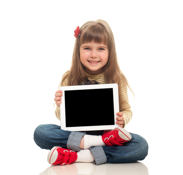 Söpö pieni tyttö yllään farkut yleistä istuu lattialla
 - Valokuva, kuva