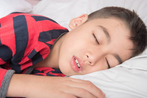 Μικρό αγόρι στον ύπνο με άσπρη κουβέρτα κάλυψη του σώματος  - Φωτογραφία, εικόνα