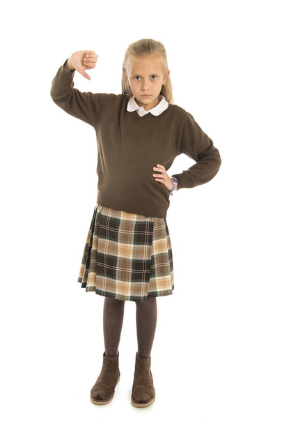 7-8-vuotias surullinen ja turhautunut koulutyttö naislapsi univormussa kärsii kiusaamisesta tai inhoaa valkoista taustaa vasten eristettyä koulua.
  - Valokuva, kuva