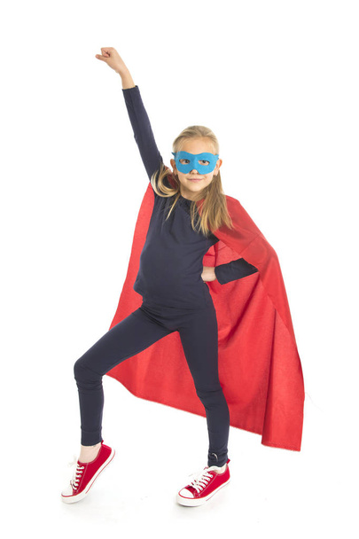 7 oder 8 Jahre alte junge Schulmädchen Kind in Superheldenkostüm Durchführung glücklich und aufgeregt isoliert auf weißem Hintergrund  - Foto, Bild