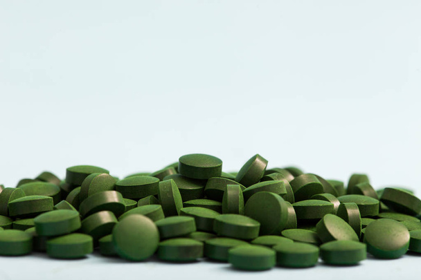 zelené pilulky spirulina nebo chlorella řasy v dřevěné misce. g - Fotografie, Obrázek