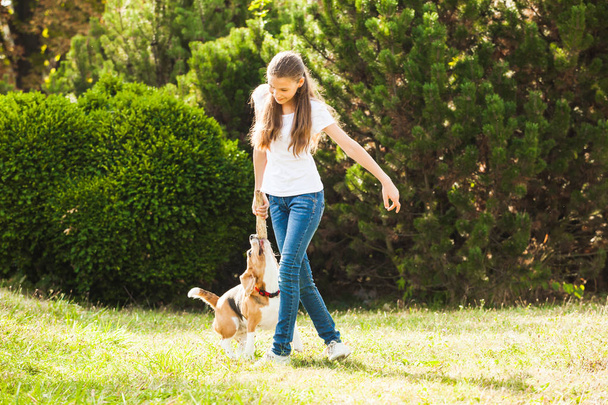 Meisje speelt met een hond in de tuin - Foto, afbeelding