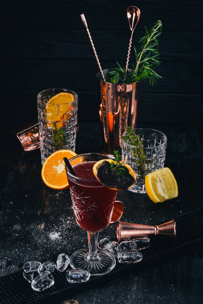 Alcoholic cocktail. Rum, peach liquor, cherry juice. On a black wooden background - Фото, зображення