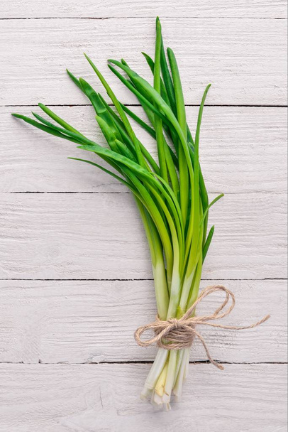 Fresh green onion on a wooden background. Top view. Free space for your text. - Foto, immagini
