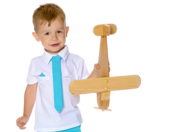 Malý chlapec hraje s dřevěným letadlem - Fotografie, Obrázek