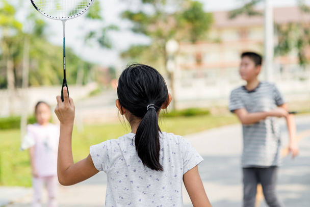 Motion blur back of girl playing badminton  with friend outdoor. - Foto, imagen