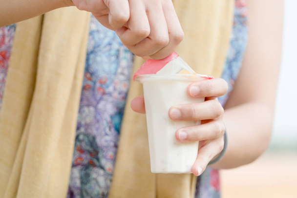 mano de las mujeres abriendo la ensalada de frutas jalea de leche de soja, yogur, postre, saludable, dulce, delicioso
 - Foto, imagen