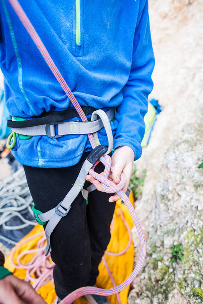 Ein Bergsteiger knüpft einen Knoten für die Versicherung. - Foto, Bild