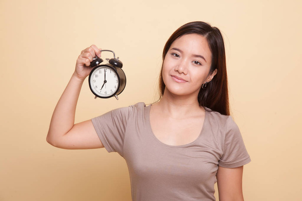 Young Asian woman with a clock. - Fotoğraf, Görsel