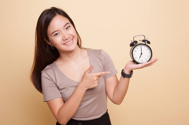 Young Asian woman point to a clock. - Foto, imagen