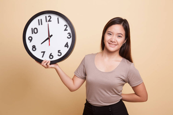 Young Asian woman with a clock. - Foto, imagen