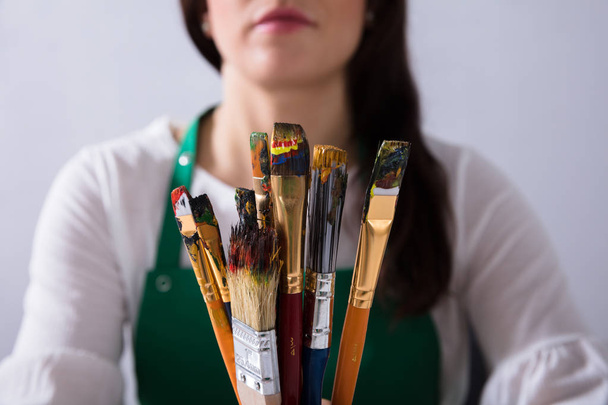 Close-up Of Various Paintbrushes In Front Of Female Artist - Foto, Bild