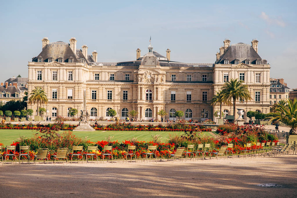 Luxembourg Gardens with yellow flowers, green grass, sculptures, chairs. Famous French Senat palace building on a sunny summer day. - Foto, imagen