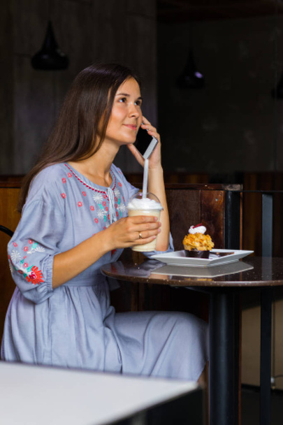 Mujer hablando con amigos por teléfono móvil en la cafetería
 - Foto, Imagen