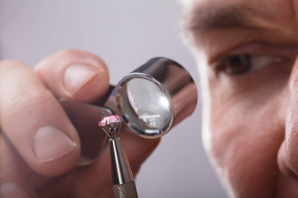 Close-up Of A Person's Hand Checking Diamond Through Magnifying Loupe - 写真・画像
