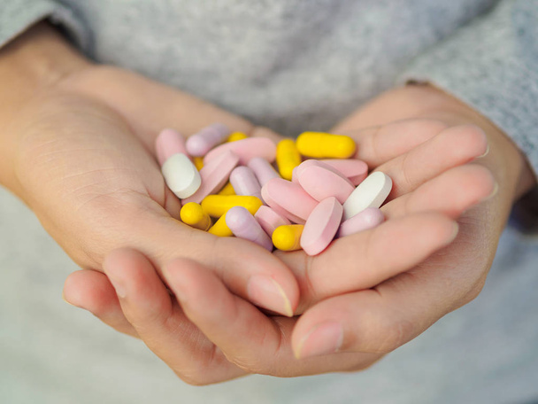 Close-up mão mulher segurando um monte de comprimidos diferentes
.  - Foto, Imagem