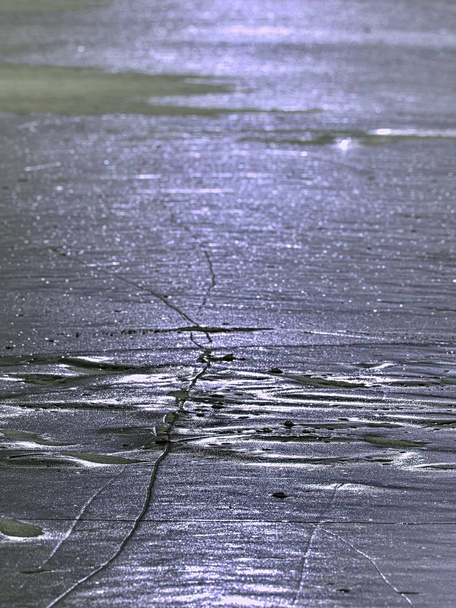 sparkling shards of cracked ice jut out on the frozen lake. The light effect occurs - Photo, Image