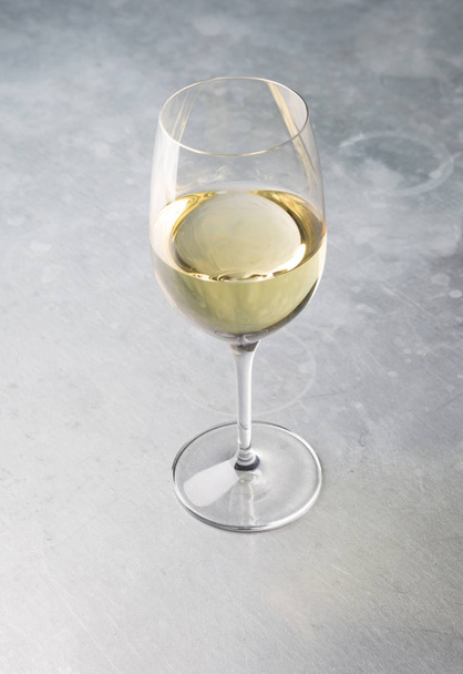 Glass of white wine on a bar counter - 写真・画像