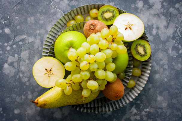 Top view of a healthy food image with fresh fruits (kiwi, apples, pears, bananas, grapes), top view, copy space - Photo, image