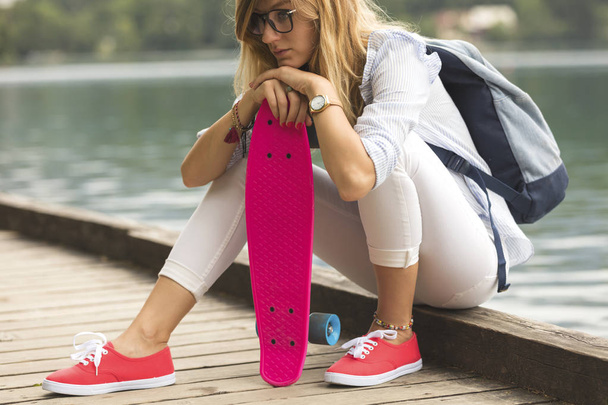 Приваблива дівчина ковзанярка з копійки скейтборд на відкритому повітрі
. - Фото, зображення