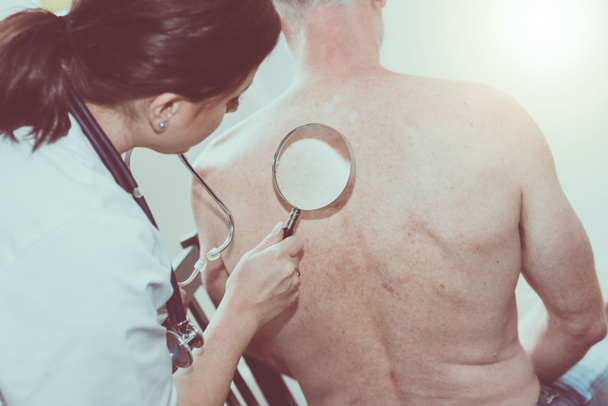 Γυναίκα γιατρός ελέγχοντας το δέρμα του ασθενούς ανώτερος - Φωτογραφία, εικόνα