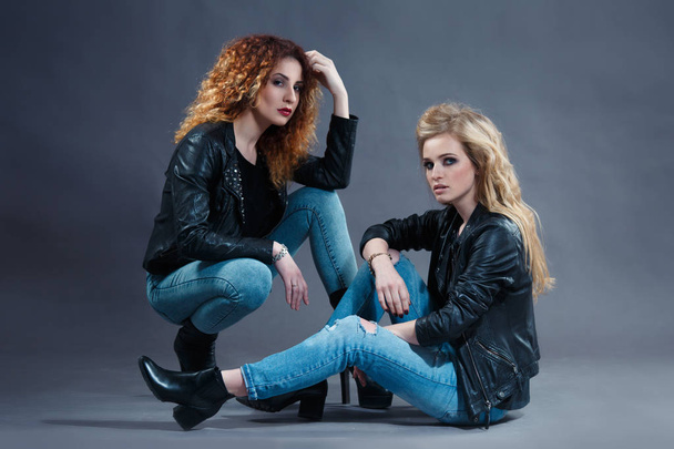 two sexy rocker girls posing on a dark background - Foto, imagen