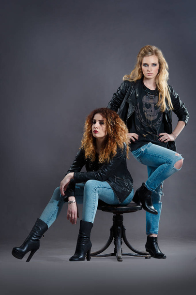two sexy rocker girls posing on a dark background - Fotó, kép