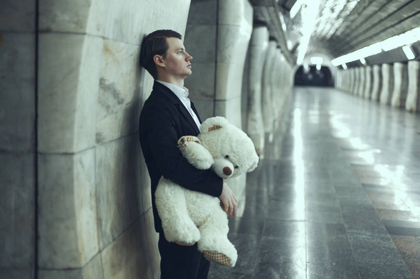 Чоловік сумний з іграшкою плюшевого ведмедя в руках
. - Фото, зображення