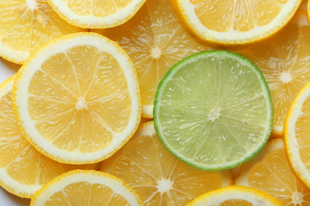 Top view of slice of lime among pieces of lemons - Φωτογραφία, εικόνα