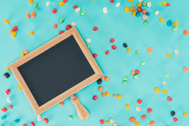 flat lay with empty blackboard and sweets isolated on blue surface, april fools day concept - Photo, Image
