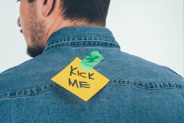 back view of man with note on sticky tape with kick me lettering on back, april fools day holiday concept - Photo, Image