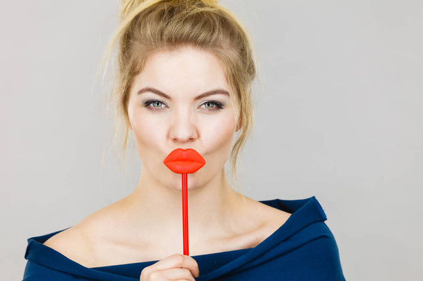 Funny woman holding big red lips on stick - Фото, изображение