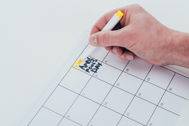 partial view of man making note on calendar isolated on grey, april fools day concept - Fotoğraf, Görsel